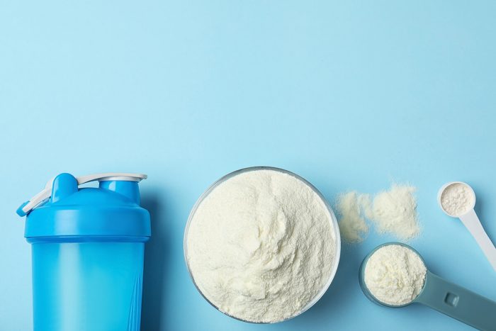 Whey protein powder with blender bottle and scooper