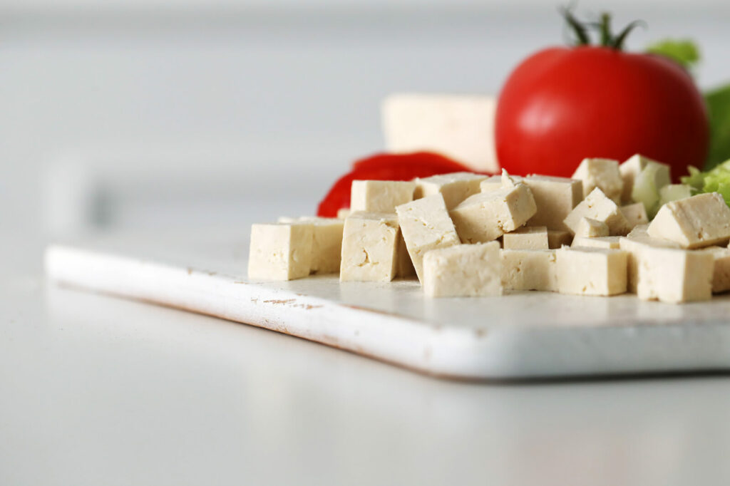 Tofu and tomato on cutting board